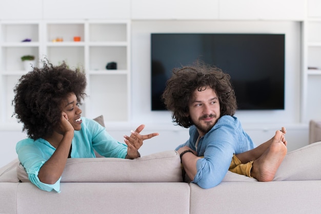 Young multiethnic couple sitting on a sofa in the luxury living room