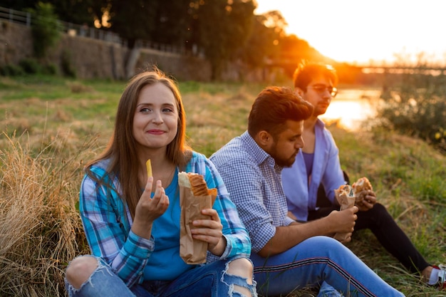 The young multiethnic students eating fastfood in campus