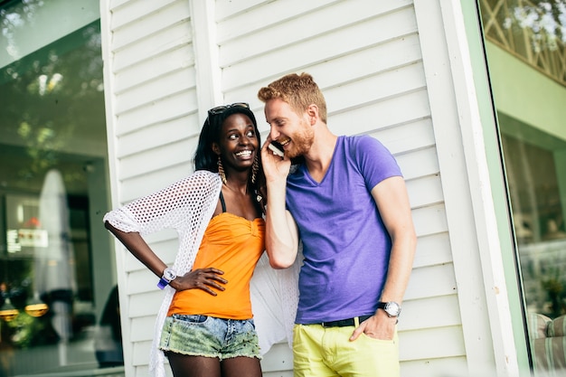 Young multiracial couple with mobile phone