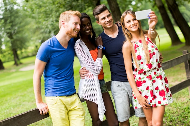 Young multiracial friends taking selfie  in the park