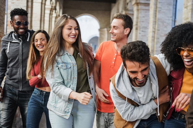 Young multiracial people having fun outdoor in the city - Focus on center girl face