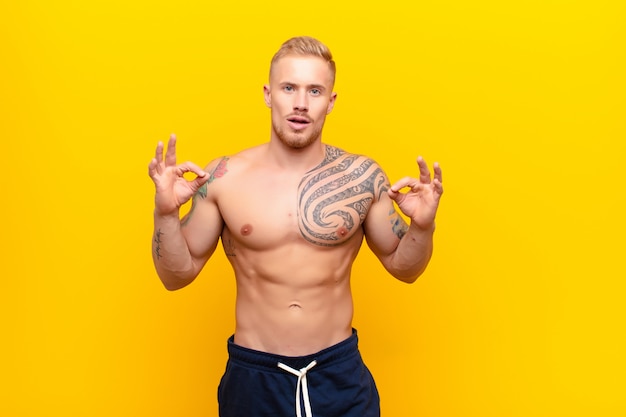 young muscular man showing approval okay sign with both hands