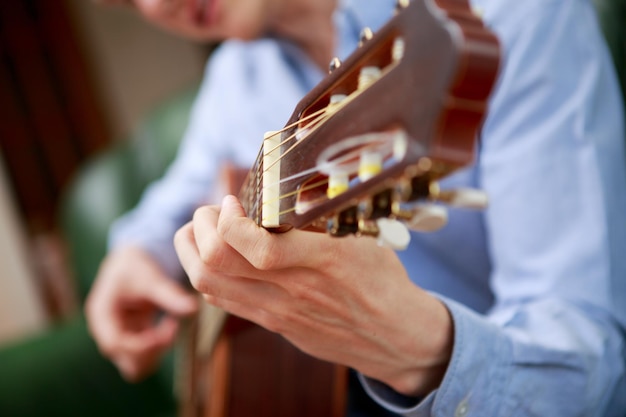 Young musician playing at acoustic guitar