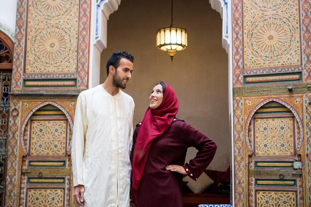 Photo young muslim couple in relationship talking and smiling in traditional moroccan riad house