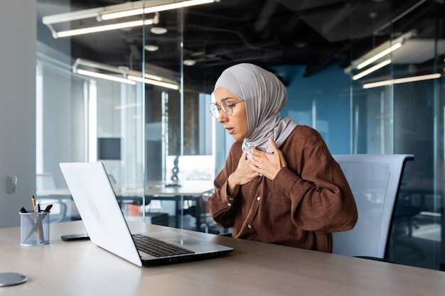 Young muslim female student muslim girl sitting in the study room at the table studying online on