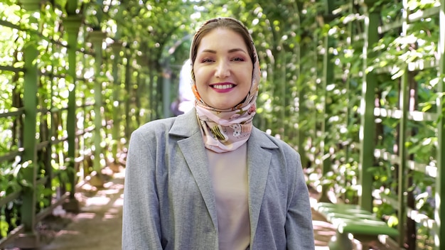 Young muslim woman in headscarf smiles in park