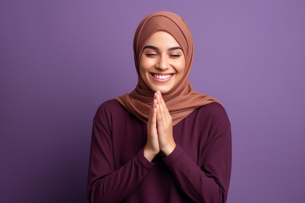 A young muslim woman in a hijab is praying and is wearing a hijab