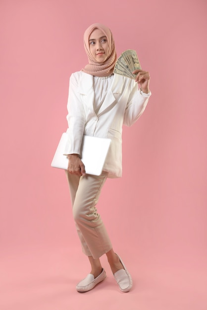 Young muslim woman hold money and laptop