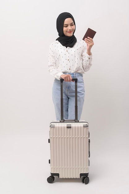 A young muslim woman tourist with baggage on white background