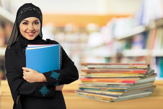 Young muslim woman with book on white