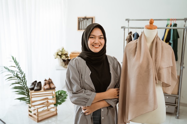 Young Muslim woman working in a clothing store