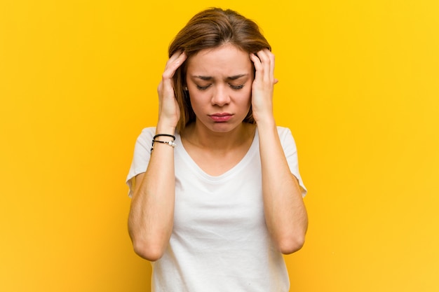 Young natural caucasian woman touching his temples and having headache.