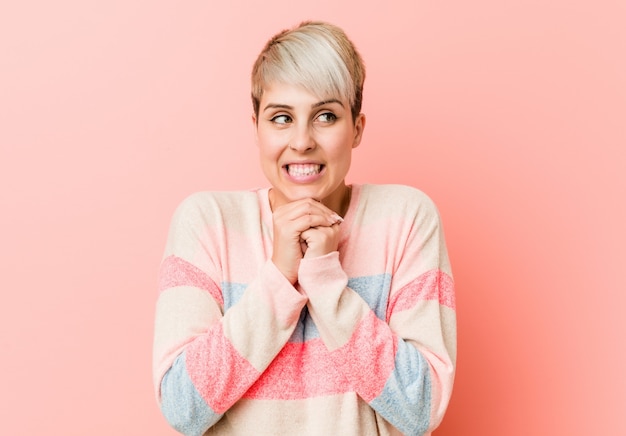 Photo young natural curvy woman keeps hands under chin, is looking happily aside