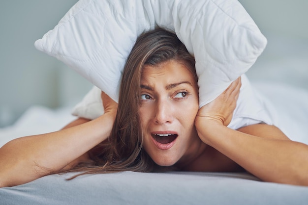 Young nice brunette woman with pillow on bed