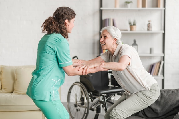 Young nurse assisting disabled senior woman