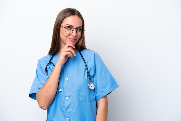 Young nurse caucasian woman isolated on white background looking to the side