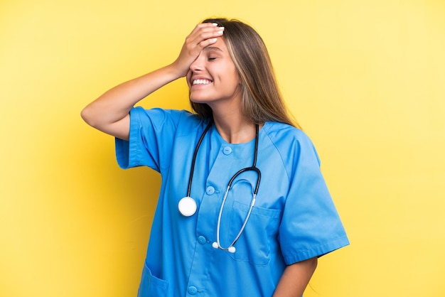 Young nurse caucasian woman isolated on yellow background smiling a lot