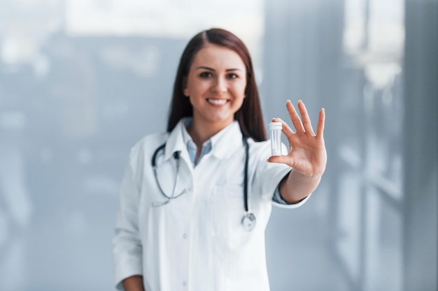 Young nurse holding drugs in hands indoors in modern clinic Conception of healthcare