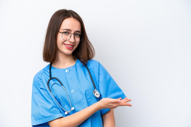 Young nurse Ukrainian woman isolated on white background presenting an idea while looking smiling towards