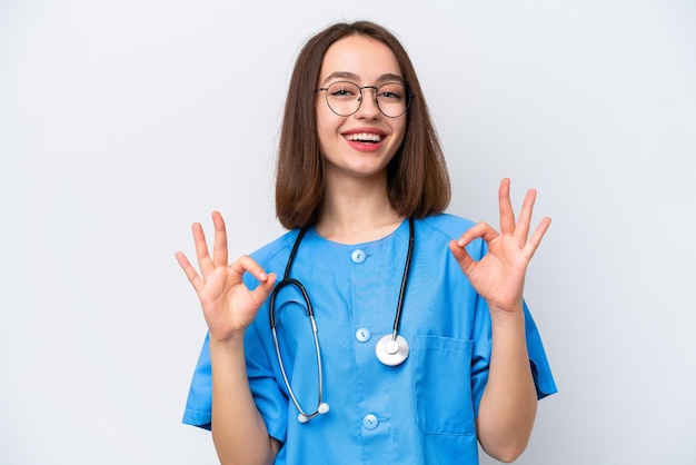 Young nurse Ukrainian woman isolated on white background showing an ok sign with fingers