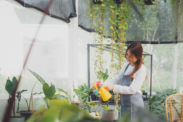 Young Nursery Worker In Greenhouse.  Home gardening, love of plants and care. Small business.