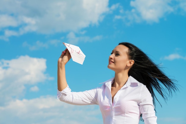 Young office lady with paper plane outdoors portrait