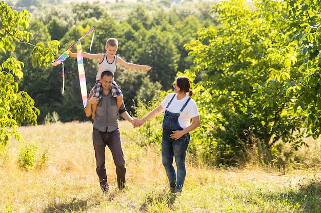 Young parents go with the son on the wheat field . The little son is happy when he is played.