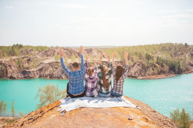 Young parents and kids on picnic after hiking in mountains Beautiful view of blue lake