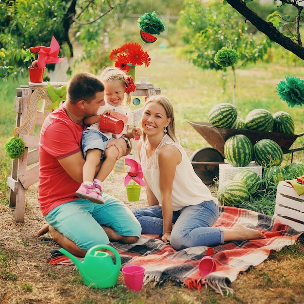 Young parents play with a small child in garden