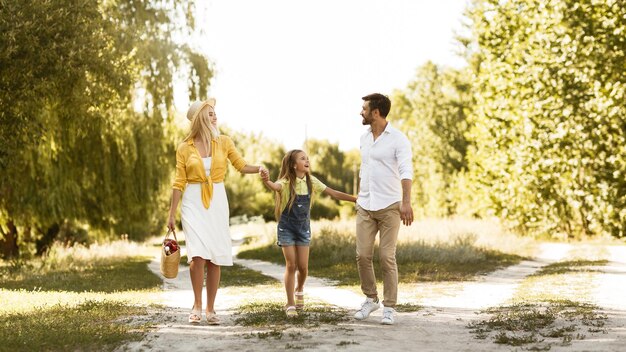 Young parents resting with daughter in countryside