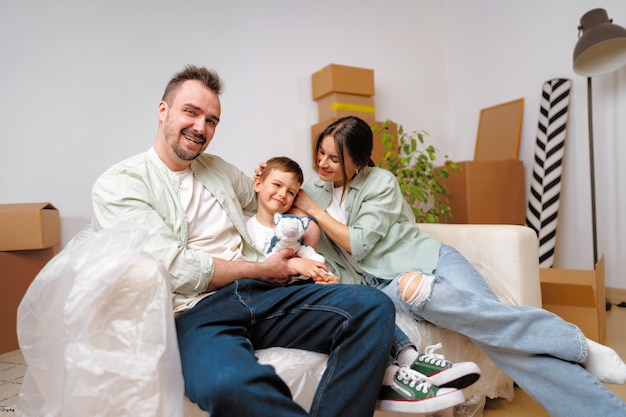 Young parents and son having fun during moving day to new house