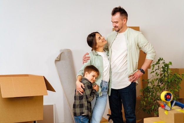 Young parents and son having fun during moving day to new house