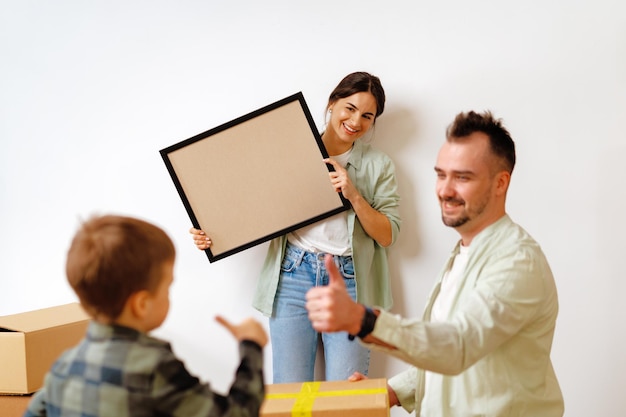 Young parents and son having fun during moving day to new house