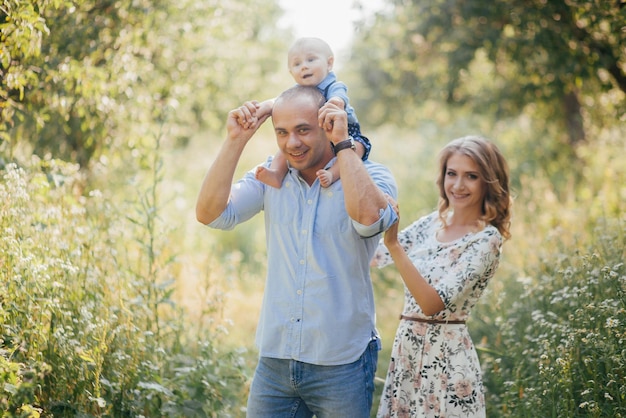 Young parents with little son in summer park