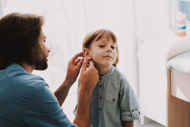 Young Pediatrician Examining Childs Ear in Clinic 