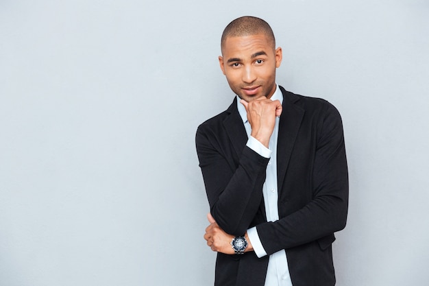 Young pensive man standing isolated