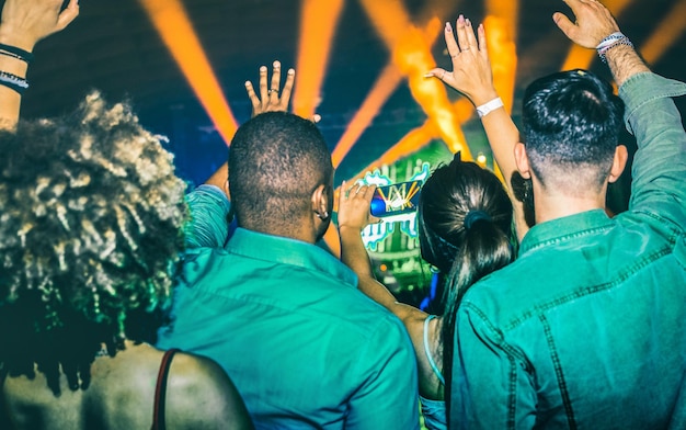 Young people dancing at night club Hands up on laser show lights at nightclub after party