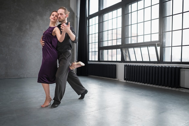 Young people dancing tango in a studio