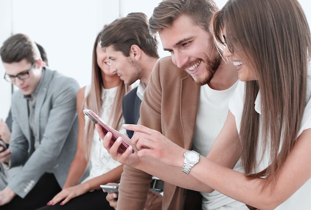 Young people of different nationalities are using gadgets talking and smiling