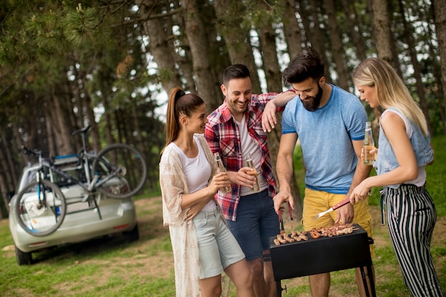 Young people enjoying barbecue party in the nature