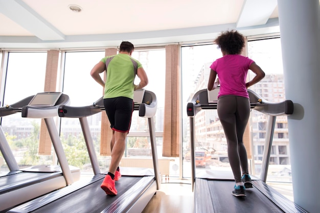 young people exercisinng a cardio on treadmill running chine in modern gym