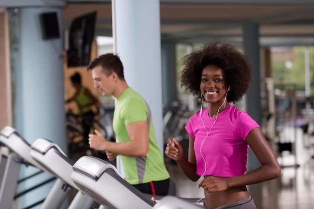 young people exercisinng a cardio on treadmill running machine in modern gym