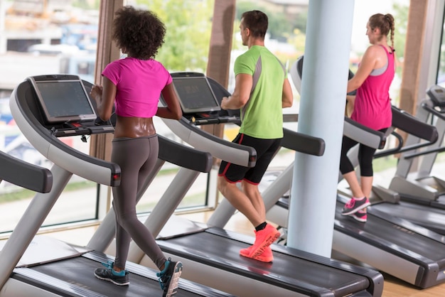 young people exercisinng a cardio on treadmill running machine in modern gym