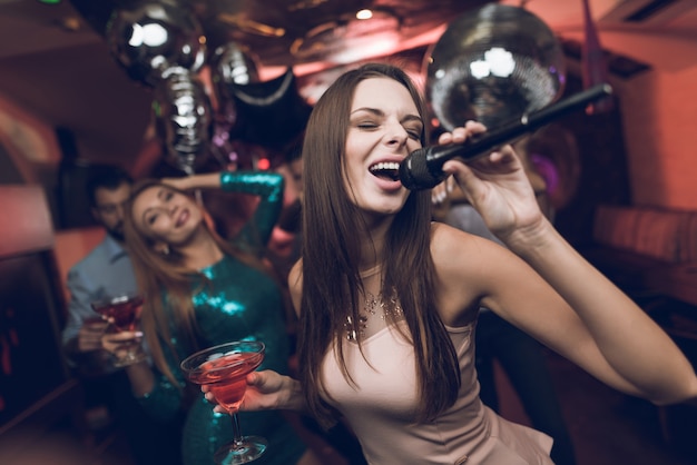 Young people have fun in a nightclub and sing in karaoke