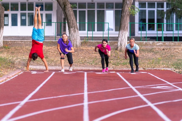 Young people lining up for a race on a track