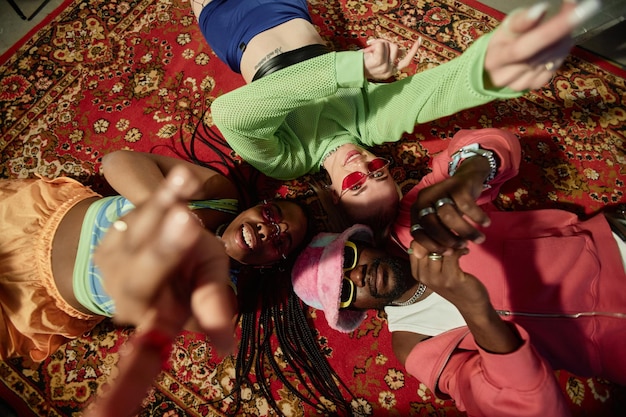 Photo young people lying on carpet in circle