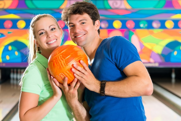 Young people playing bowling and having fun