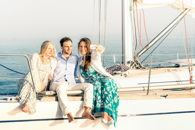 Young people taking selfie on exclusive luxury sailing boat