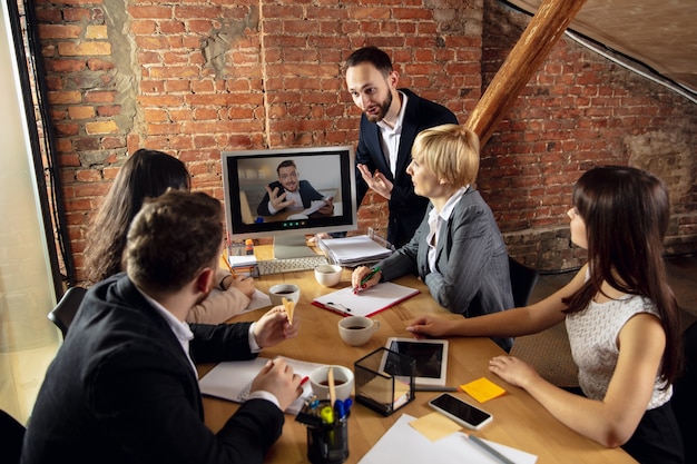 Young people talking working during videoconference with colleagues at office or living room