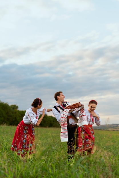 Photo young people in traditional clothes full shot